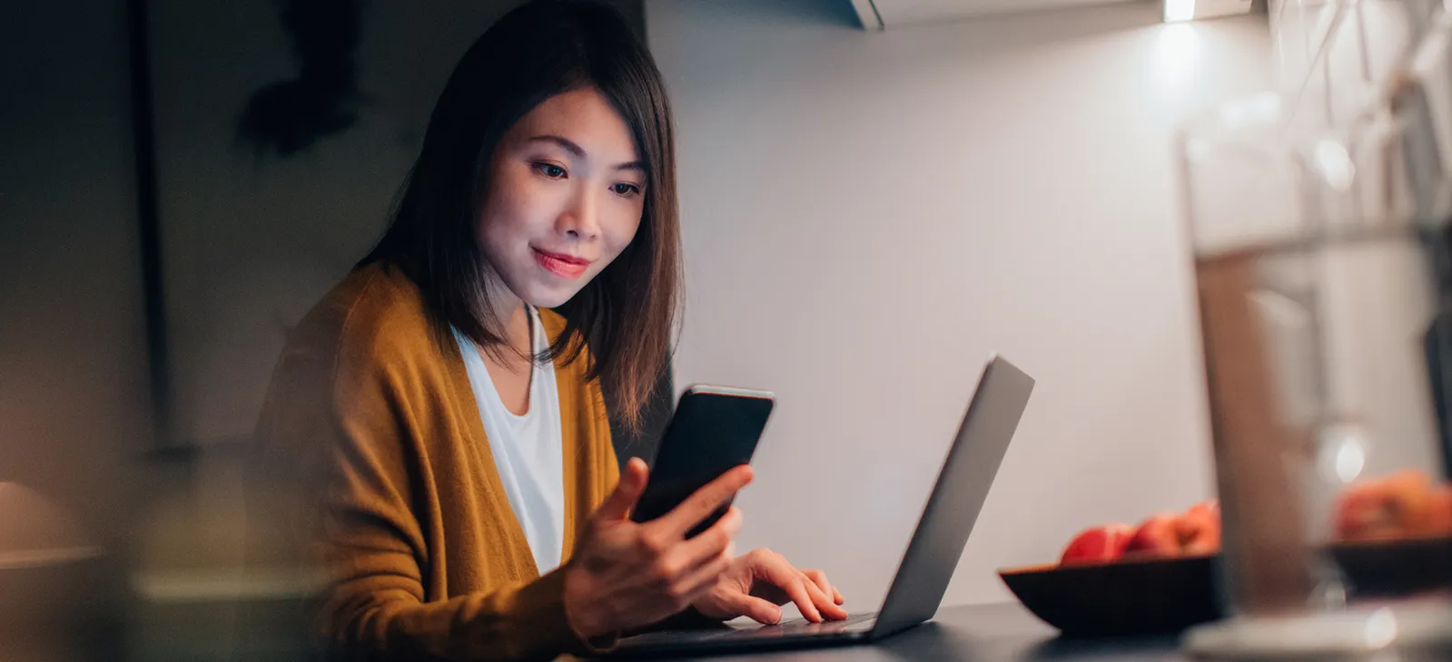 A woman using a mobile phone and laptop for banking